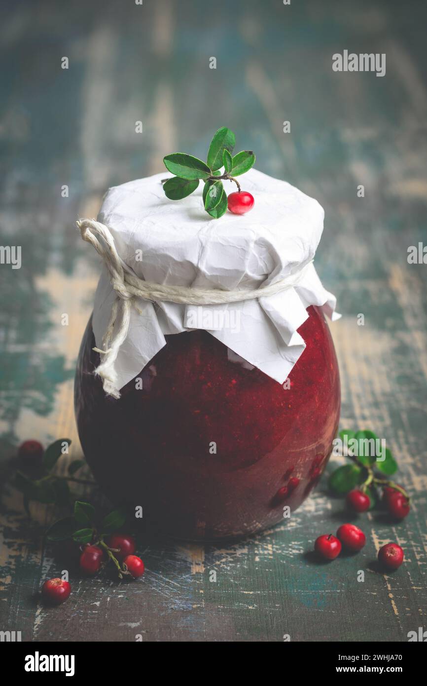 Lingonberry jam in jar and fresh berries. Selective focus Stock Photo