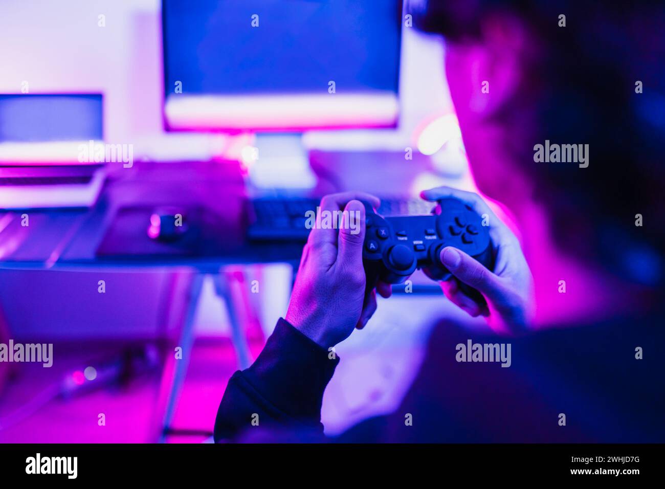Young gamer having fun playing online video games at home - Gaming entertainment and technology concept Stock Photo