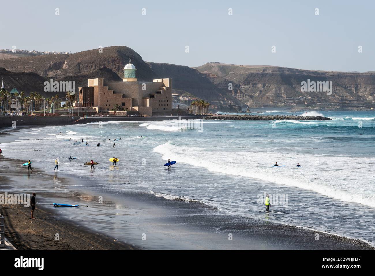 GRAN CANARIA, SPAIN - DECEMBER 12, 2023: Surfers enjoying the waves at La Cicer beach (Las Canteras) in Las Palmas de Gran Canaria in the Canary Islan Stock Photo