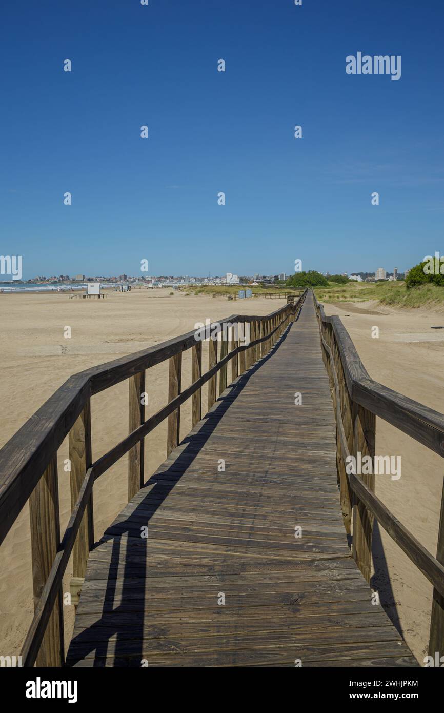 Wooden walkway extends along the beach of the port of Mar del Plata. Stock Photo