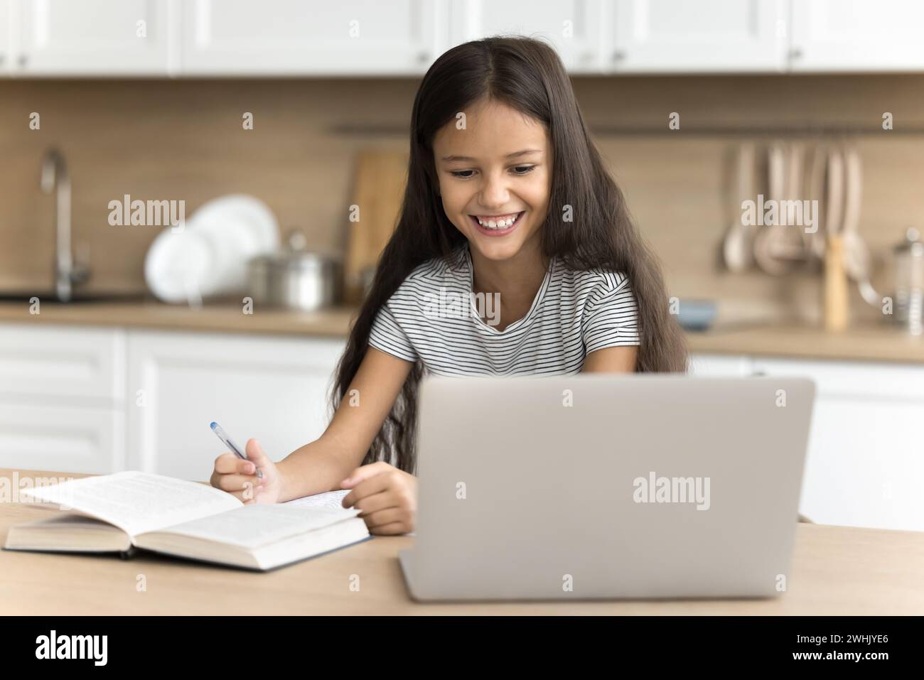 Happy preteen schoolchild girl studying online at home Stock Photo - Alamy