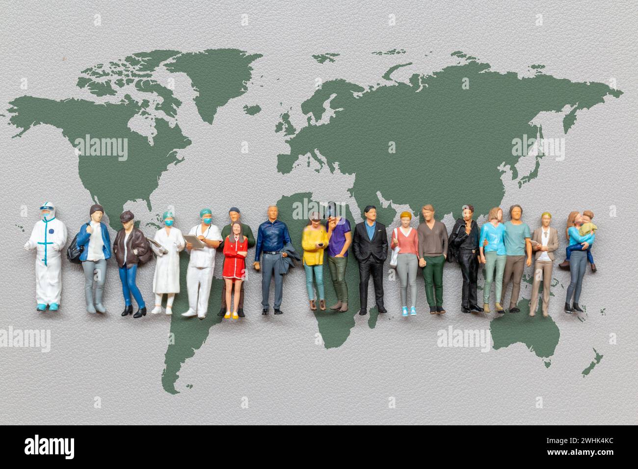 Miniature people standing on the world map with gray background Stock Photo