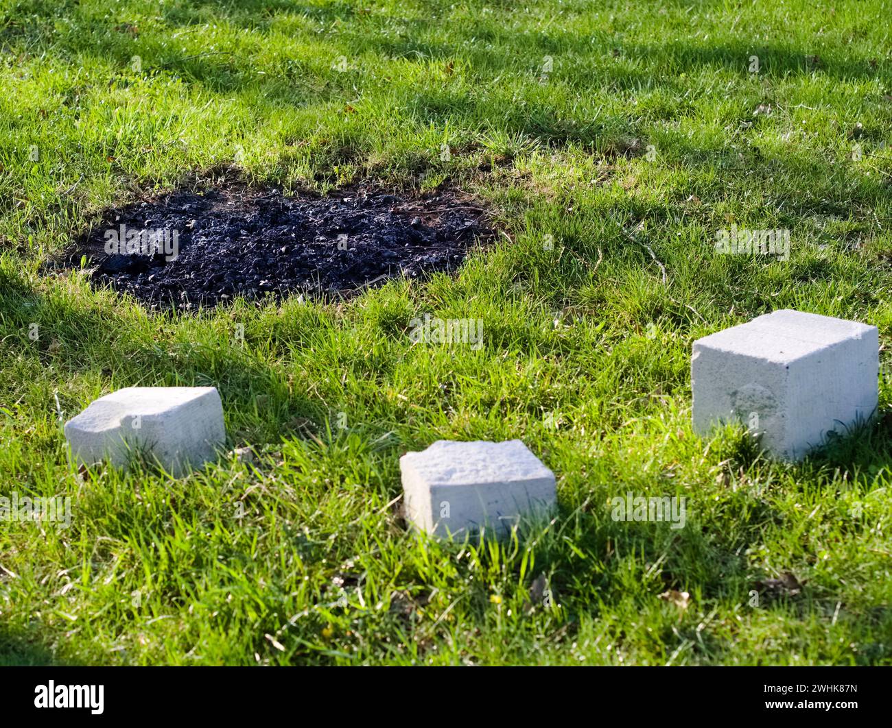 Abandoned outdoor camp fireplace on a green lawn with cement blocks and