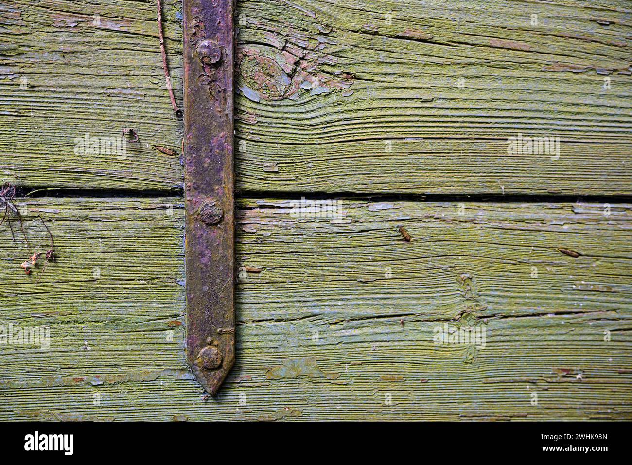Rusty iron fitting on weathered greenish wood, vintage background texture with large copy space Stock Photo