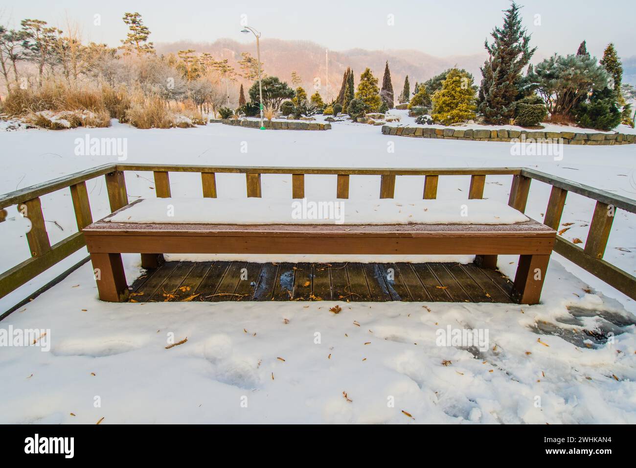Landscape of a park bench on wooden platform in a public park covered ...
