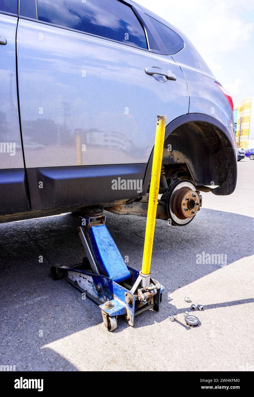 Wheels replacement. Lifting car and changing wheels using trolley jack