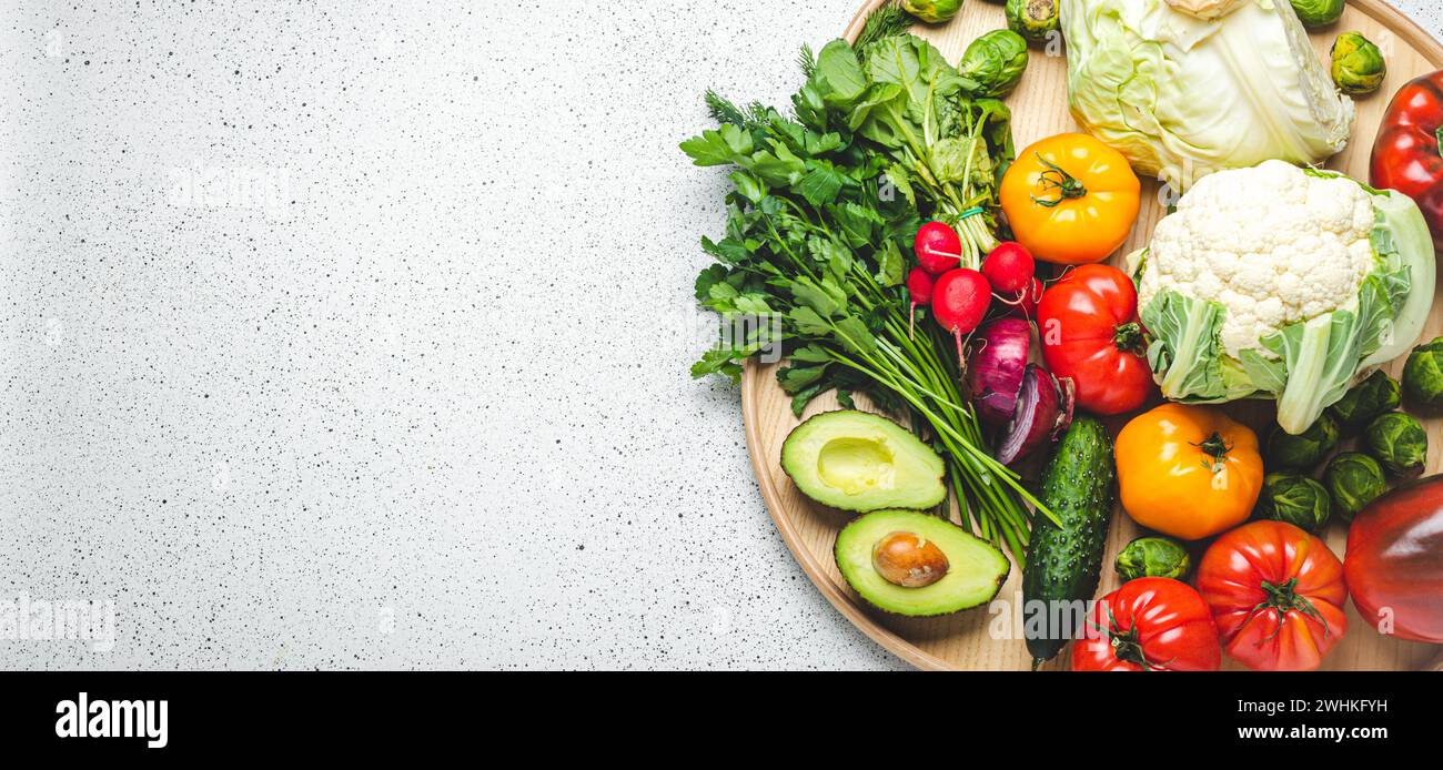 Rustic wooden tray with selection of fresh vegetables and greenery on ...