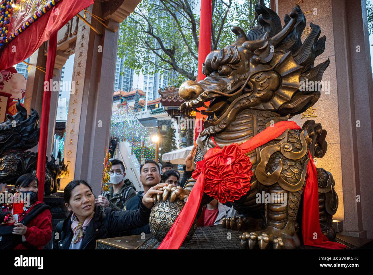Hong Kong, China. 10th Feb, 2024. A woman touches a dragon statue for ...