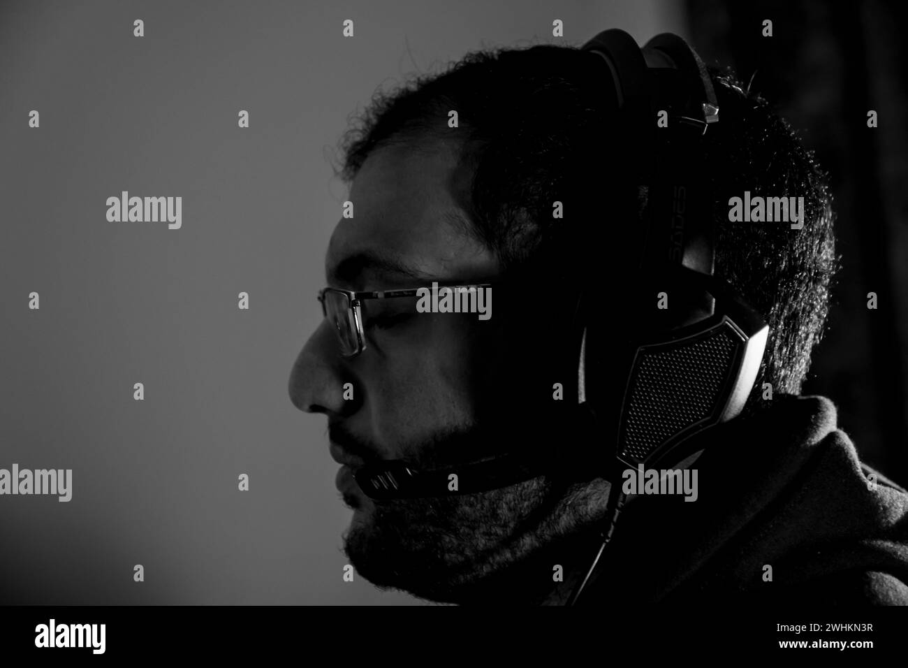 Arabic guy wearing his headset while playing online game Stock Photo