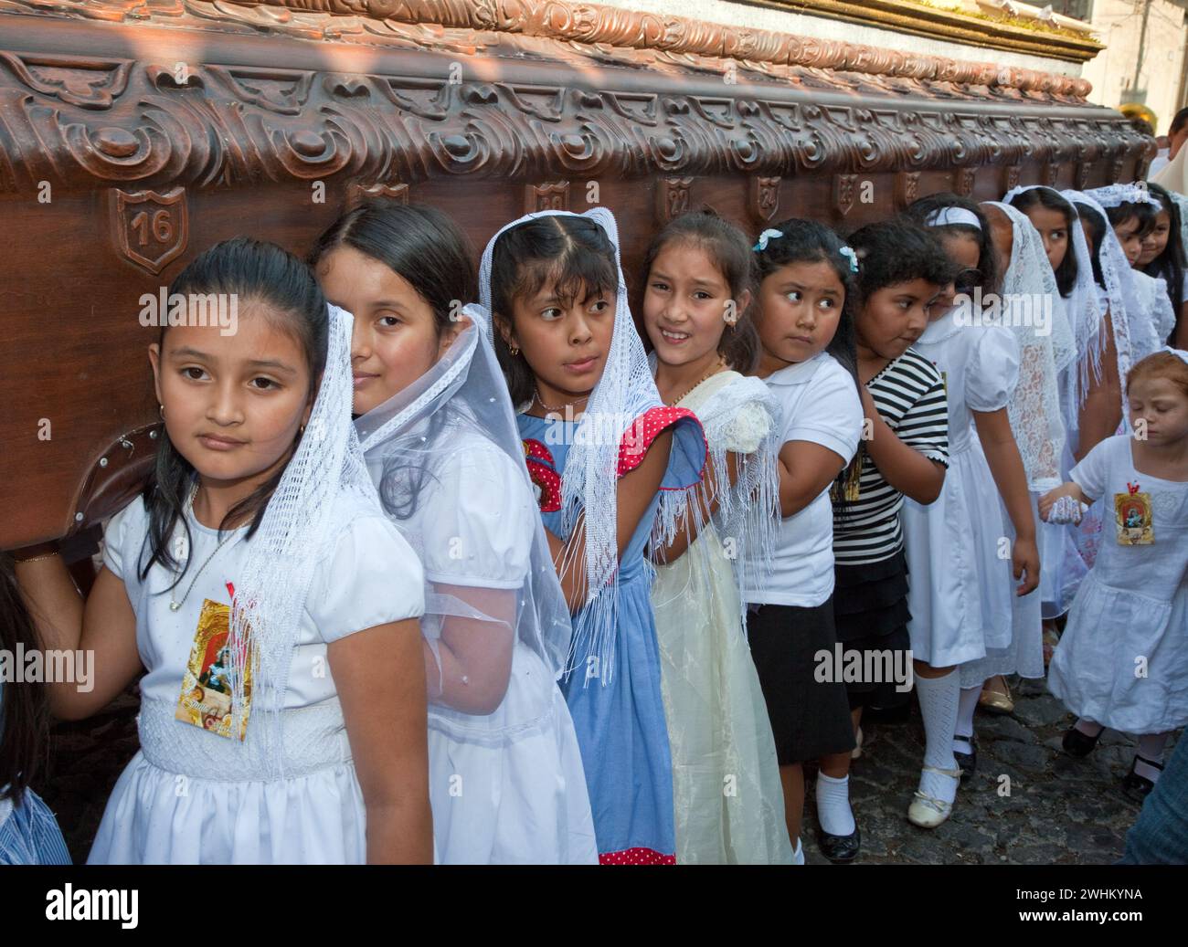 Antigua, Guatemala.  Semana Santa (Holy Week).  Young Girls Carry an Anda (Float) in a Religious Procession. Stock Photo