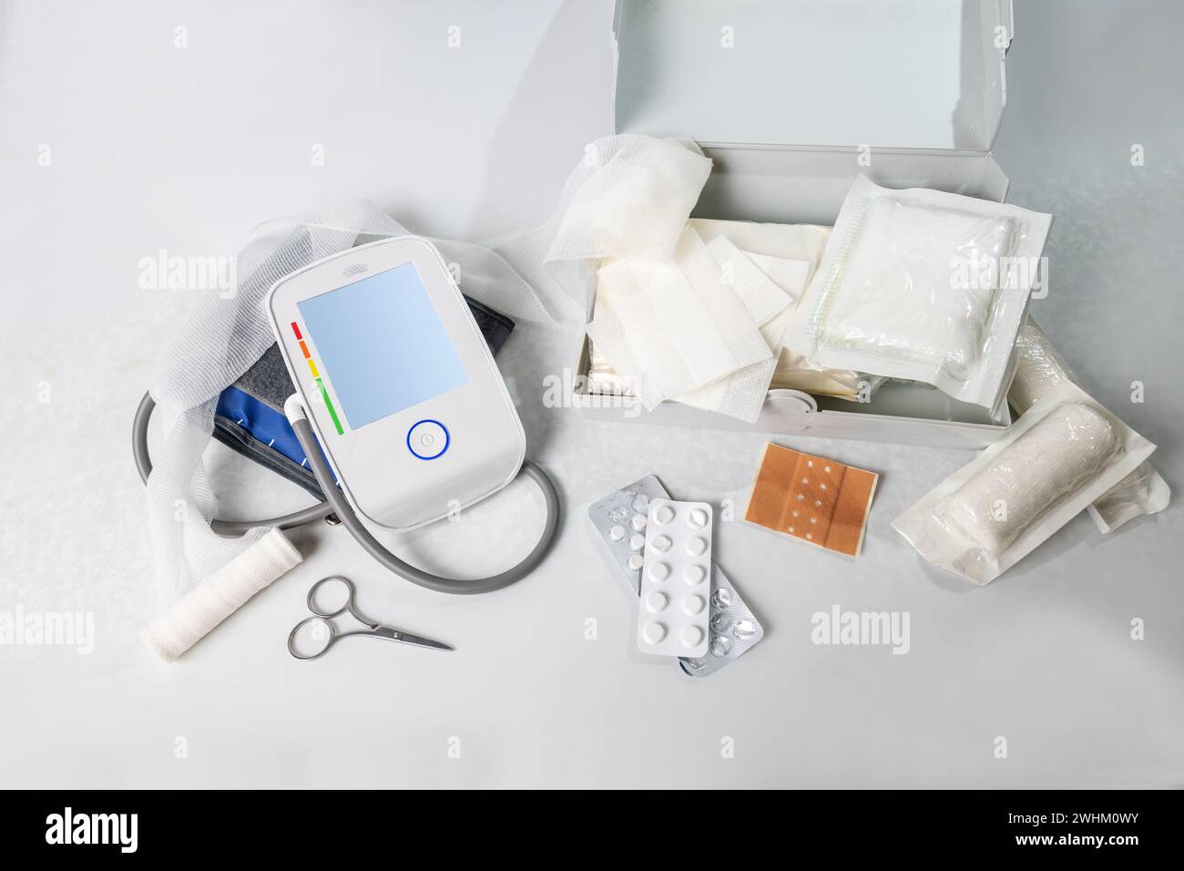 Medical supplies for first aid and the home medicine chest like blood pressure gauge, bandages, plasters, pills and scissors, li Stock Photo