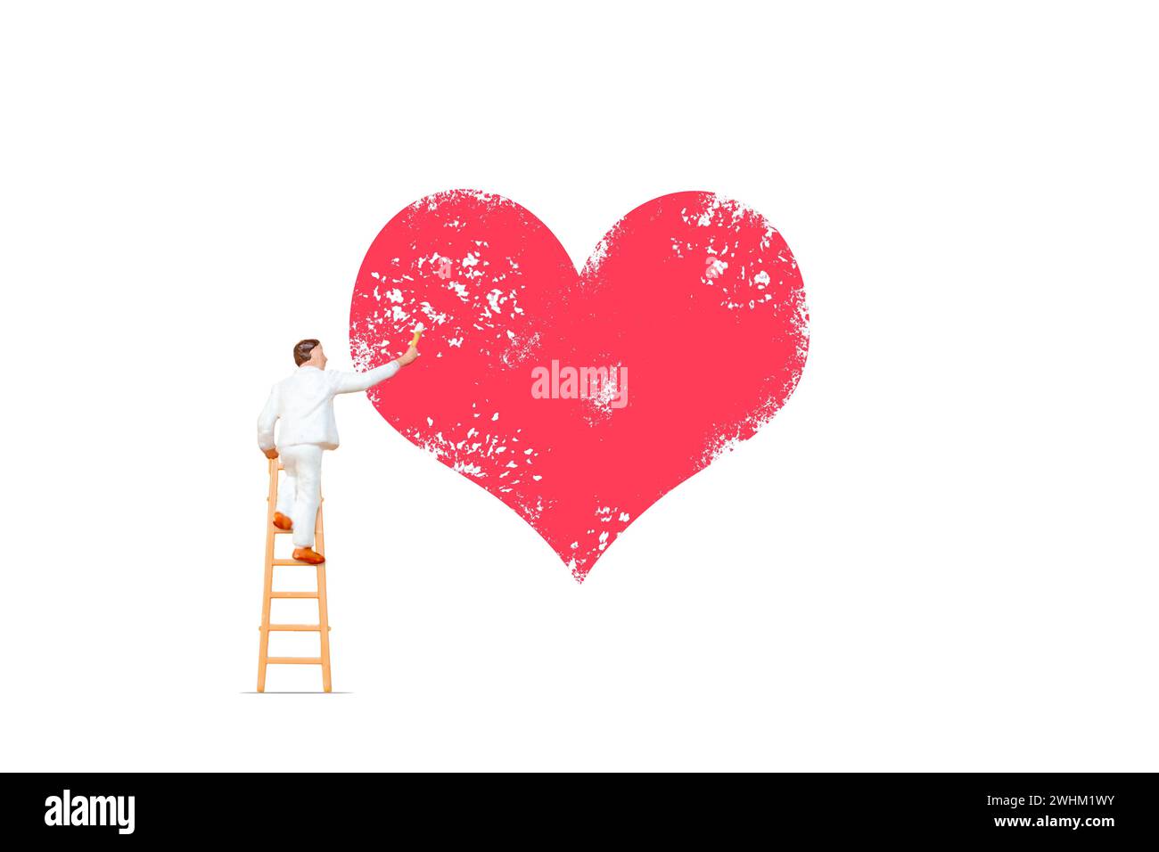 Miniature people, Artist holding paintbrush and painting with red heart shape on white background Stock Photo