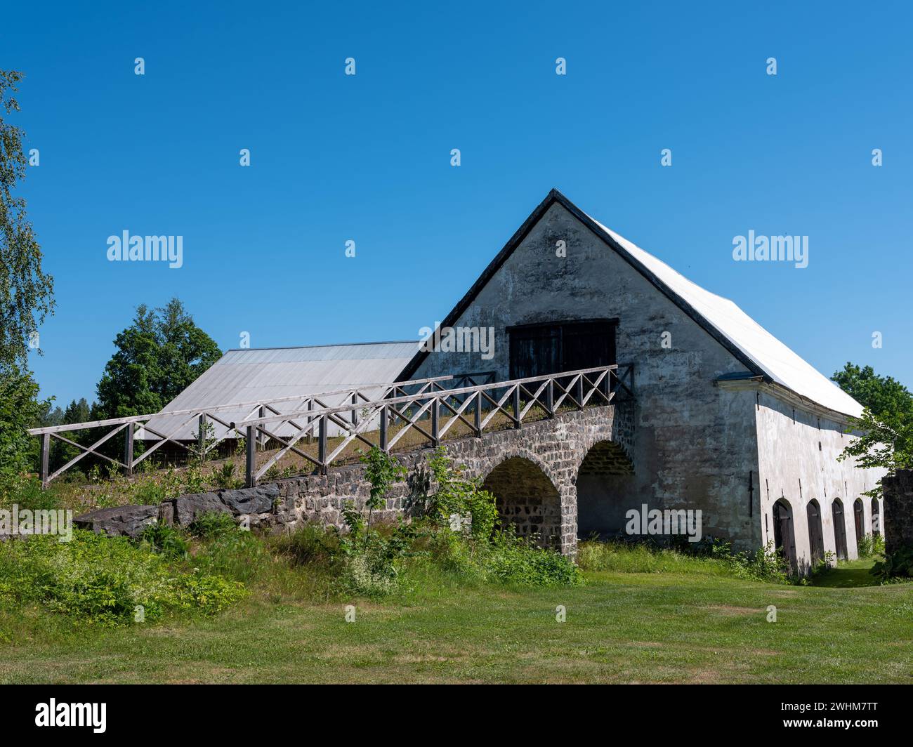 Stone ramp with arches leading to storage house with white plastered ...