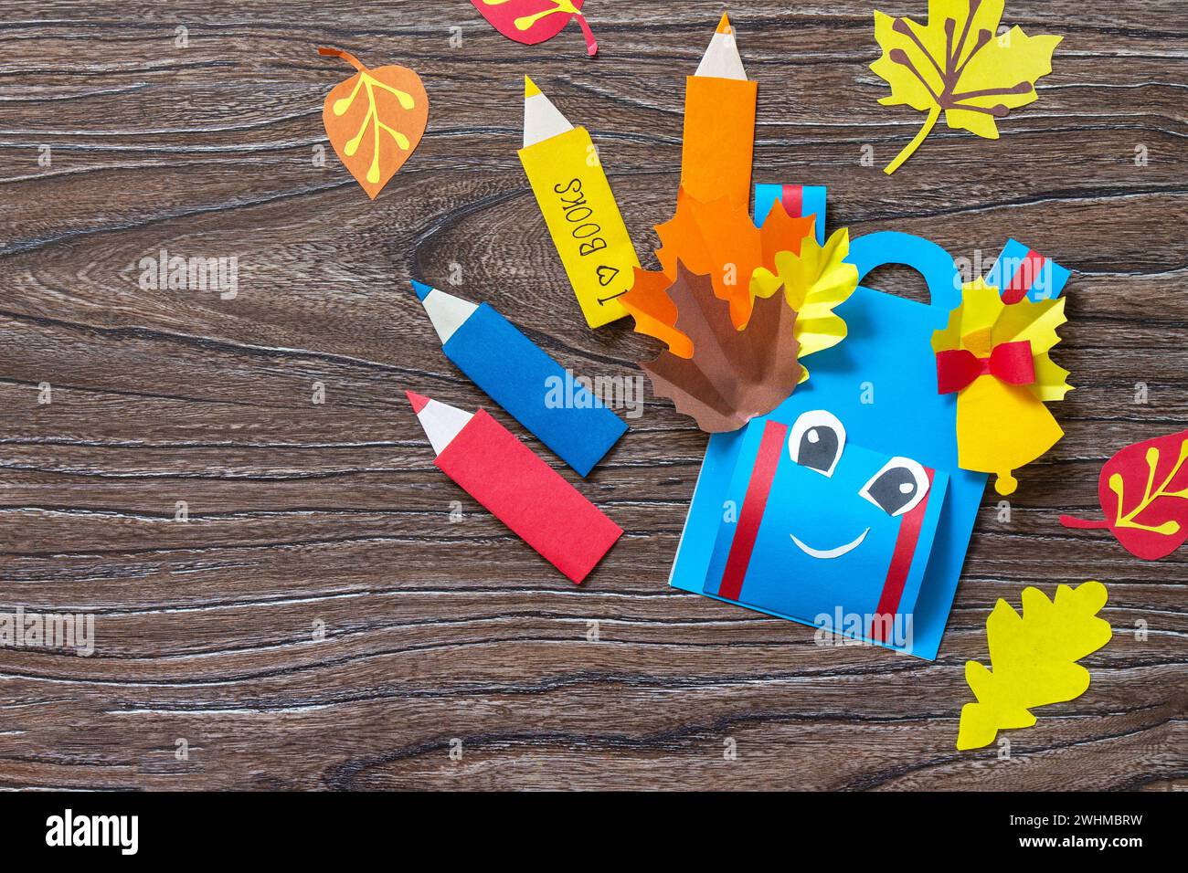 Greeting card paper backpack on a wooden table. Back to school concept ...