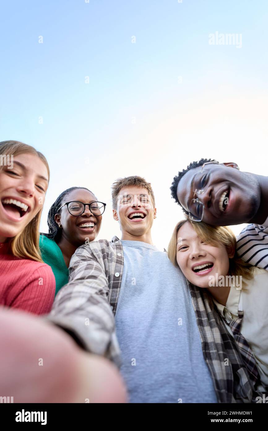 Portrait large group multiracial friends posing smiling and looking to camera. Happy young people Stock Photo