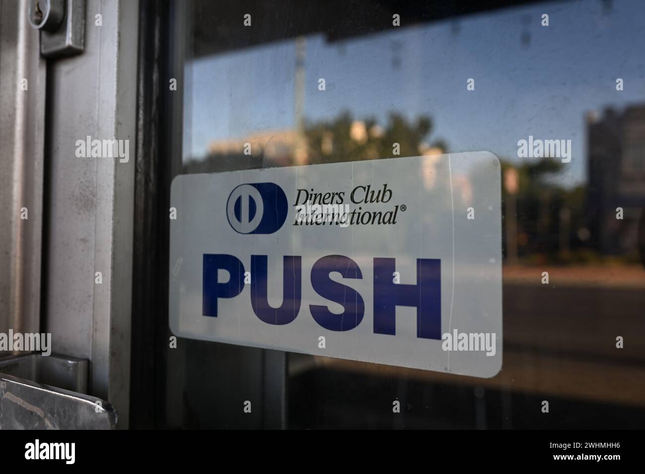 Old white and blue Diners Club International sticker, featuring the company's logo and the word push, on the window of a restaurant door Stock Photo