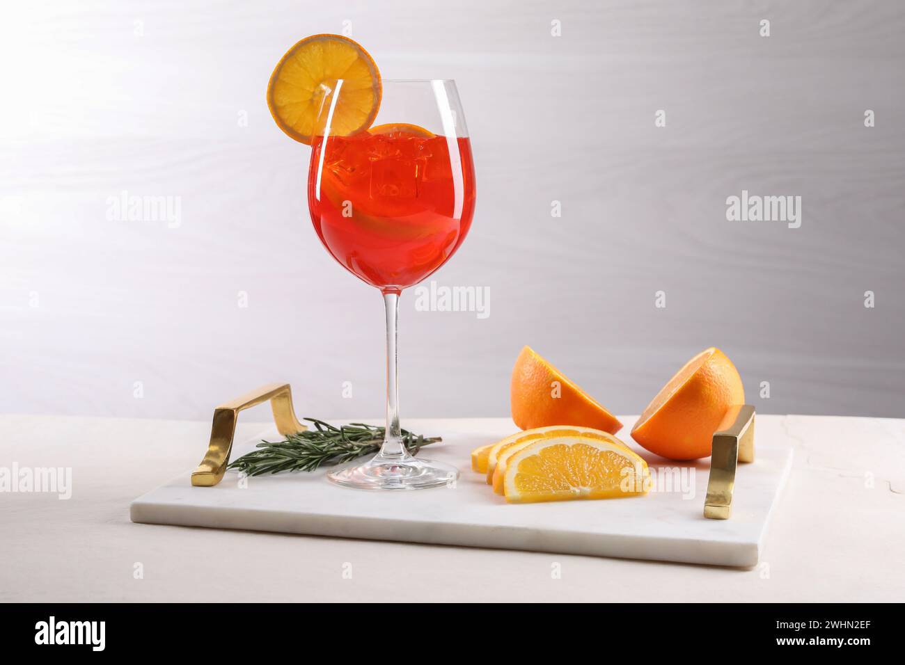 Glass of tasty Aperol spritz cocktail with orange slices and rosemary ...
