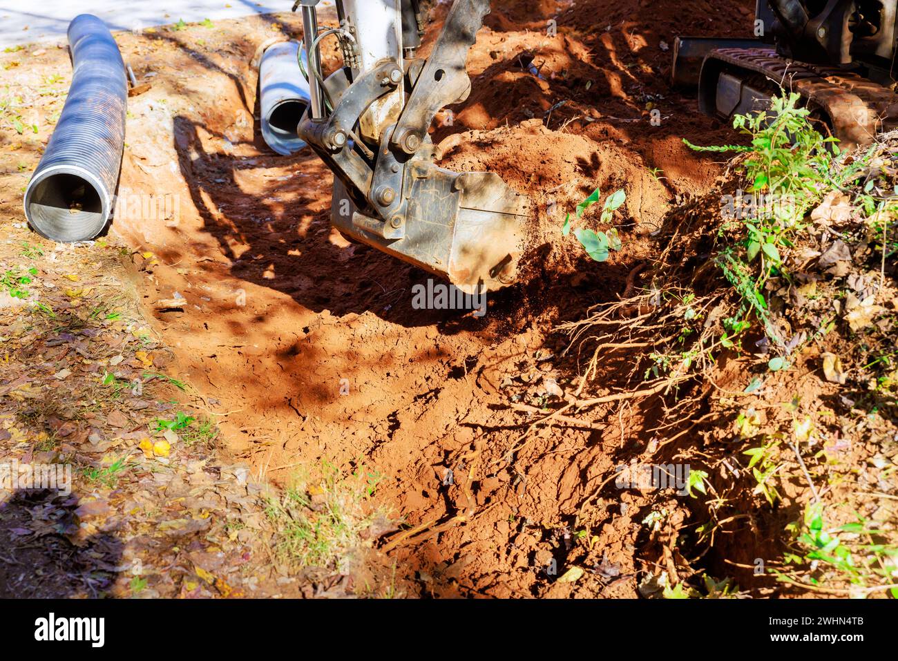 Excavators dig trenches for laying of pipe through which rainwater will be collected Stock Photo