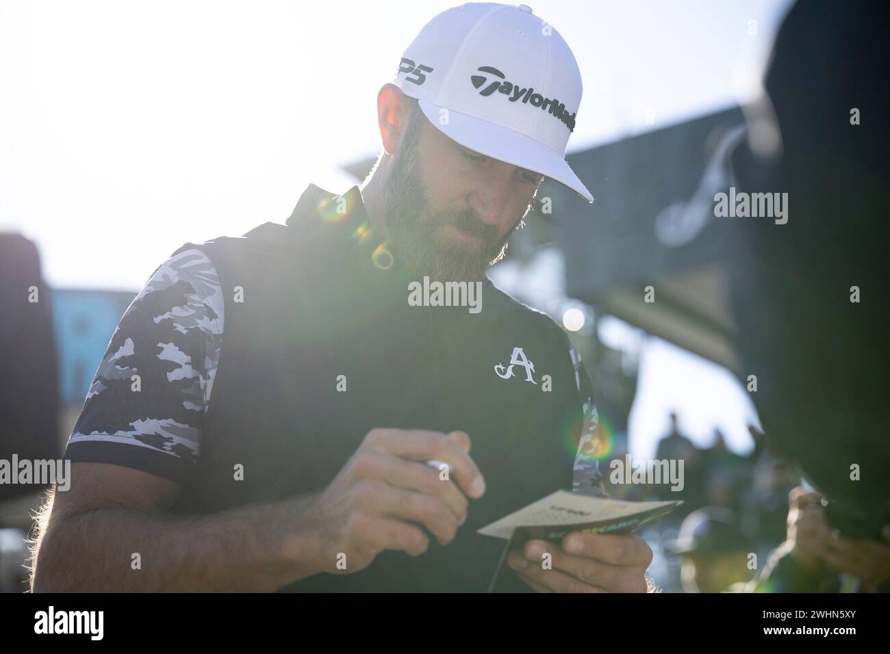 Captain Dustin Johnson of 4Aces GC checks his scorecard on the 18th