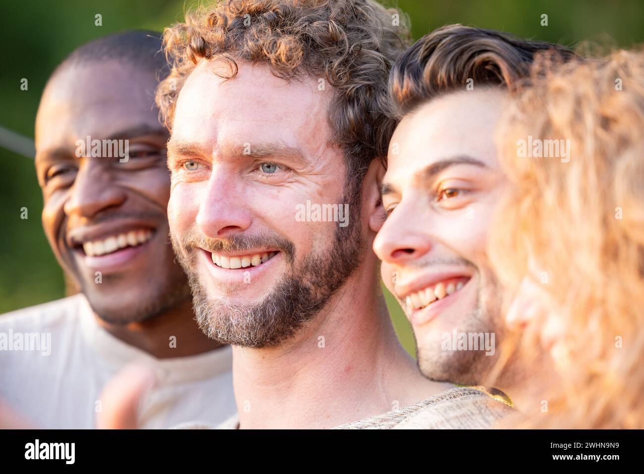Multiracial group of friends having fun together on city street - Millenial people laughing hugging outside - Friendship concept Stock Photo