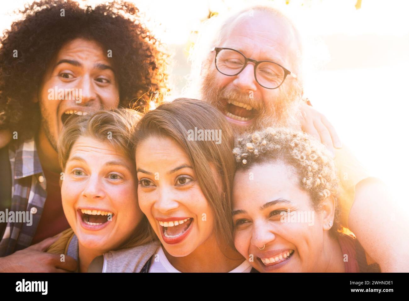Joyful Moments: Multiracial Friends Embrace Countryside Sunset Stock Photo