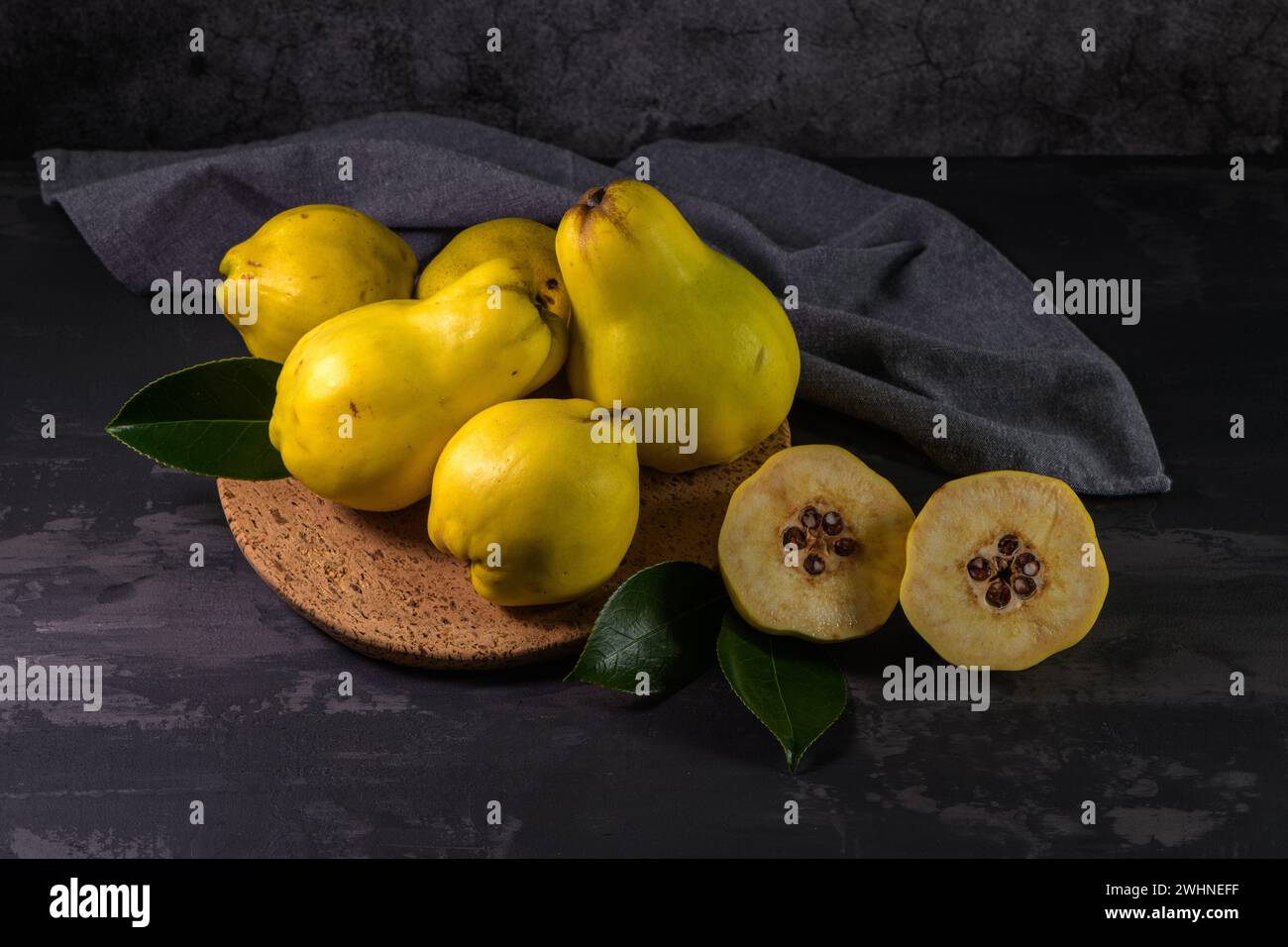 Ripe yellow quinces or queen apple fruits and sliced quince halves with