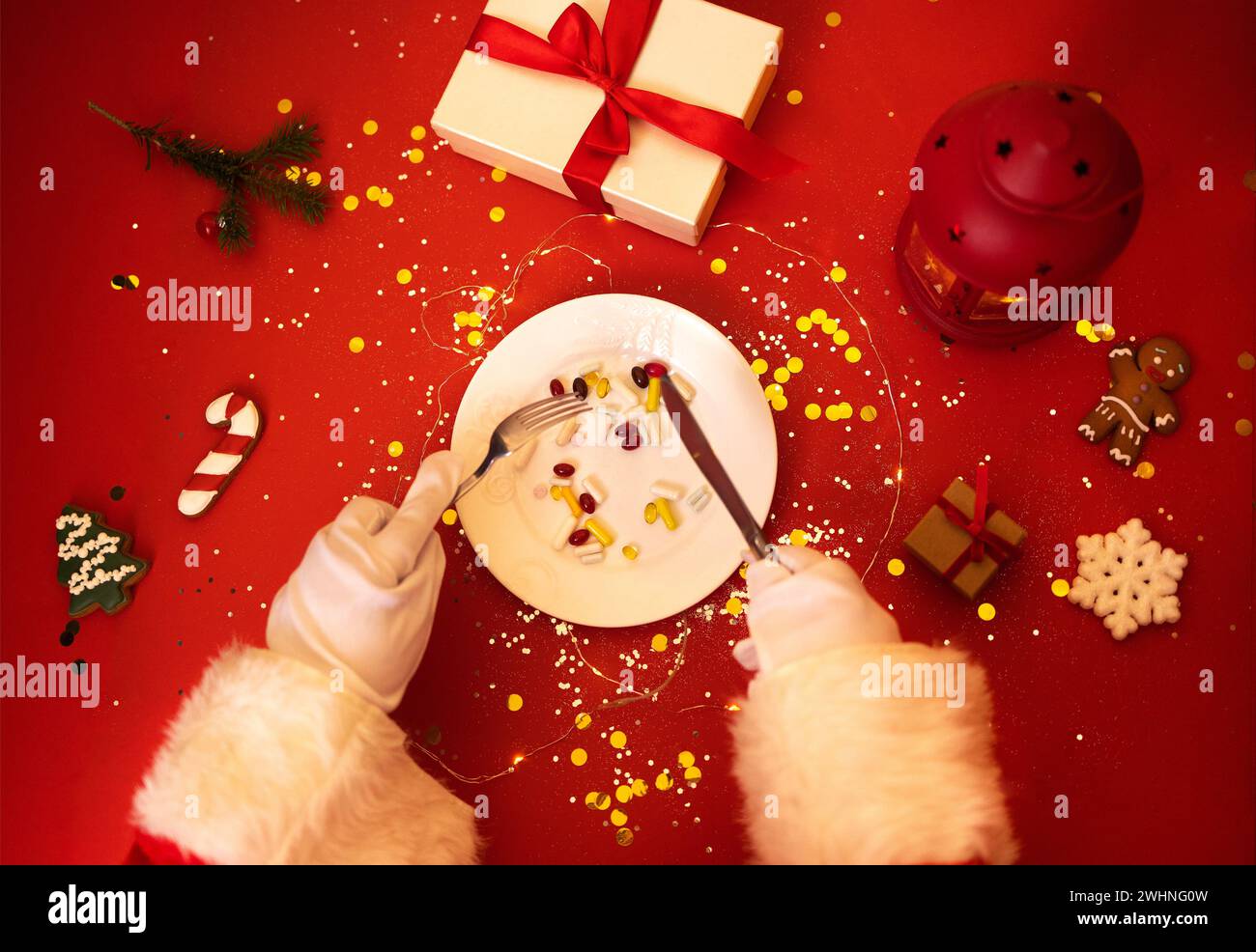Santa Claus with plate with tablets, pills and capsules. Hands in white gloves hold knife and fork. Stock Photo