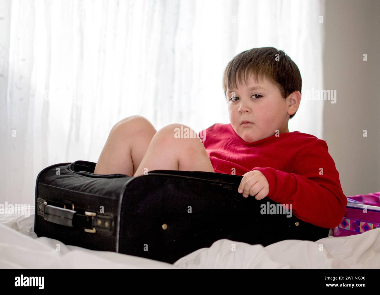 Stubborn Little boy in a suitcase says you don’t go without me Stock ...