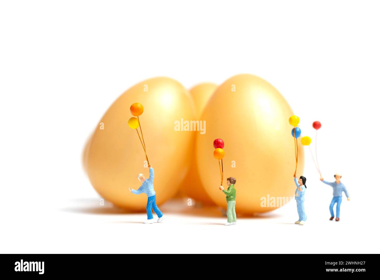 Miniature people : Happy family holding balloon celebrating Easter Stock Photo