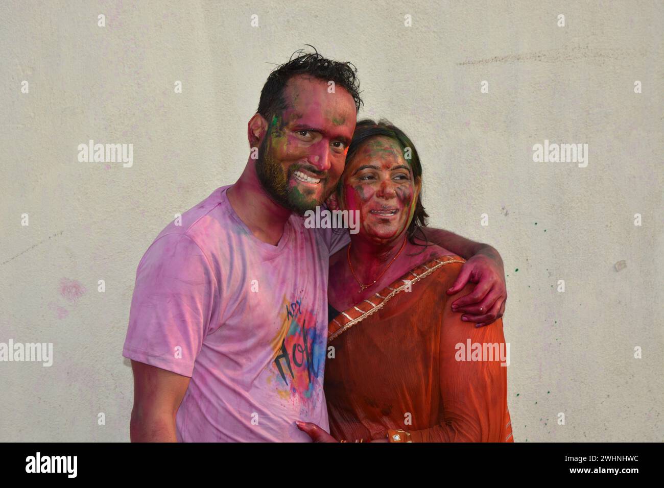 Portrait of a young Indian boy and girl playing holi. Happy couple enjoying in holi festival. Portrait of Indian couple covered in holi colors. Happy Stock Photo