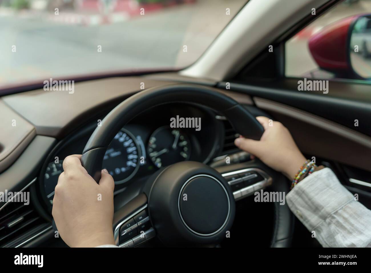 Woman driving car. girl feeling happy to drive holding steering wheel and looking on road Stock Photo