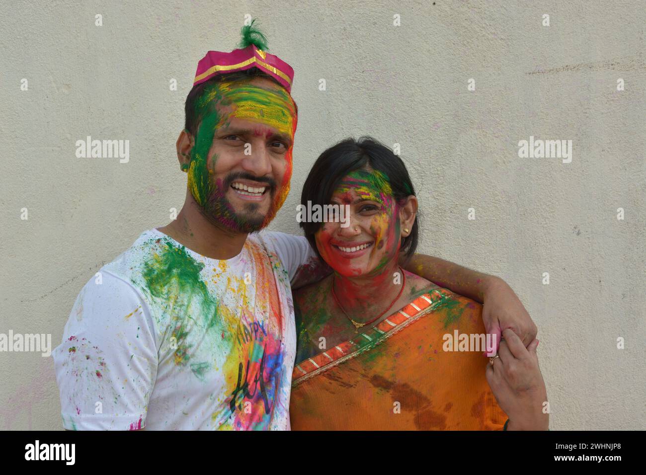 Portrait of a young Indian boy and girl playing holi. Happy couple enjoying in holi festival. Portrait of Indian couple covered in holi colors. Happy Stock Photo