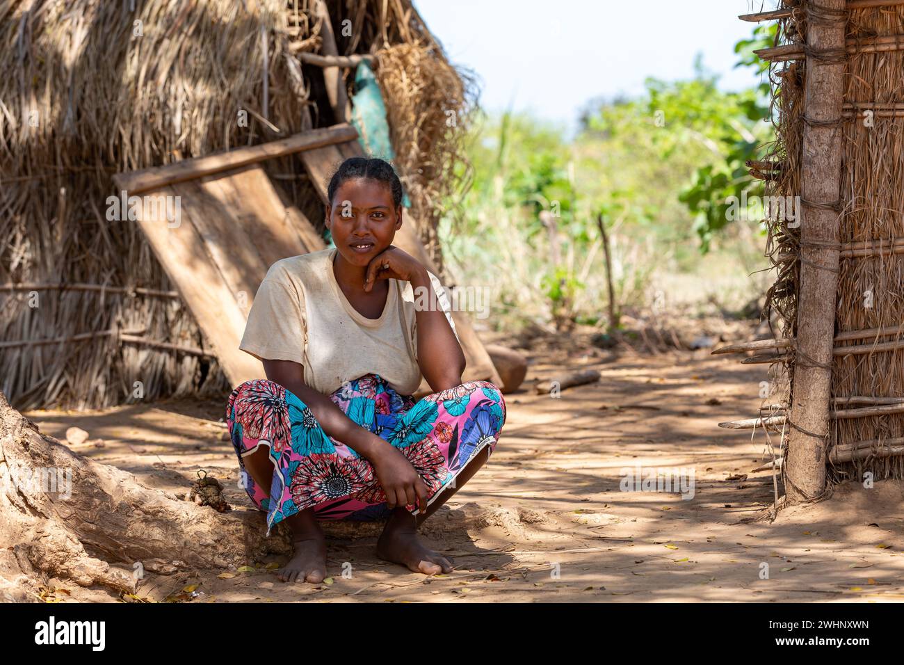 Malagasy woman in front of her hut resting in shaddow. Belo Sur Tsiribihina, Madagascar Stock Photo