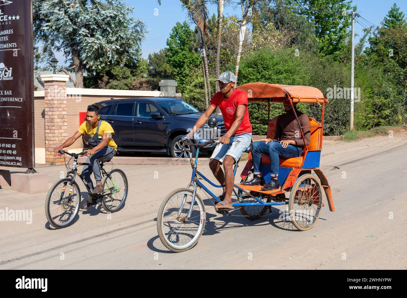 Traditional rickshaw on the Antsirabe city streets. Rickshaws are a ...