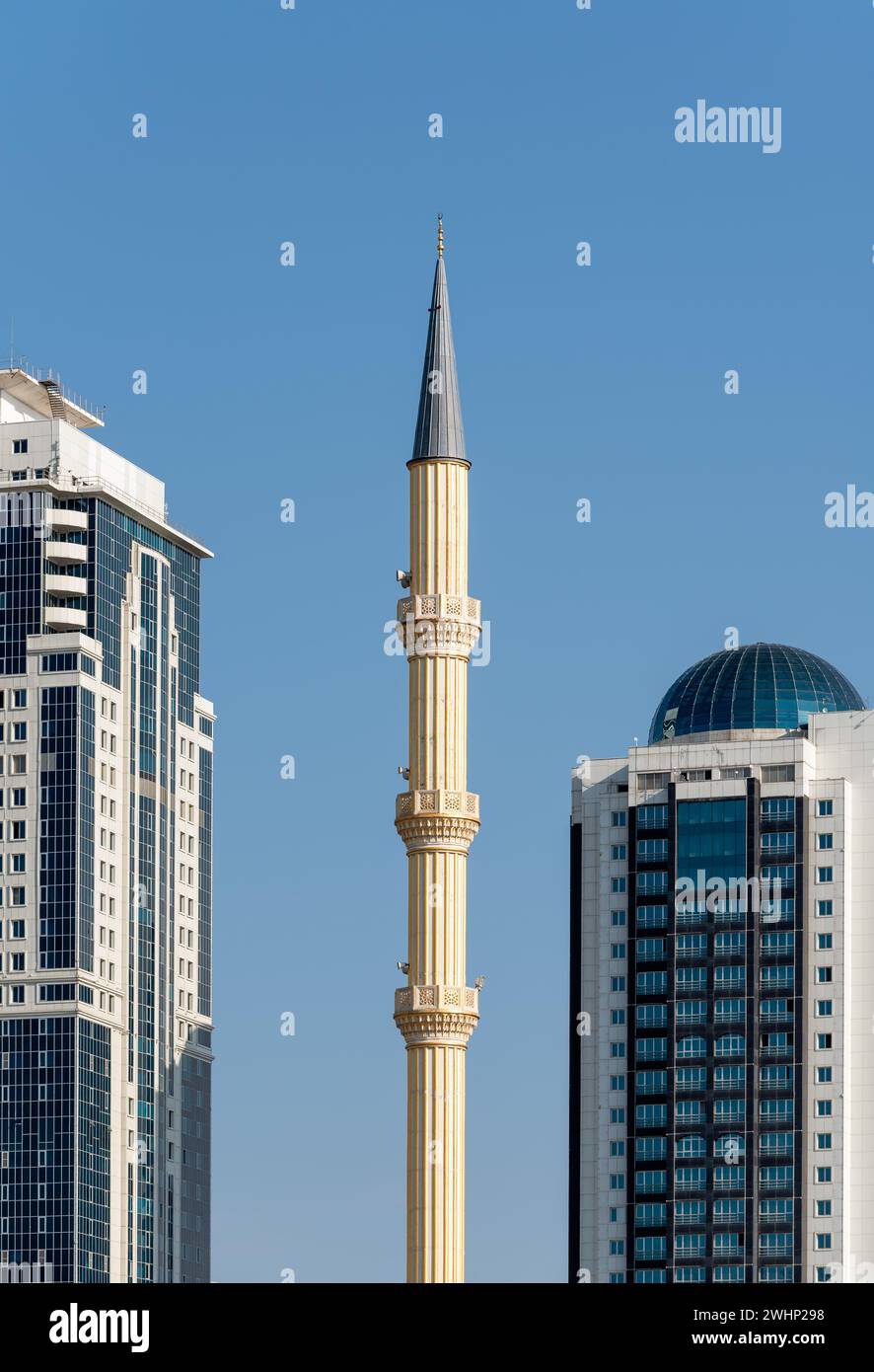 Minaret of traditional Islamic mosque and tall modern skyscrapers in Grozny Chechnya Stock Photo