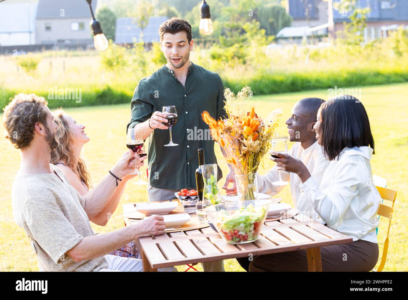 Multiracial Millennial Friends Raise Glasses in Toast Stock Photo