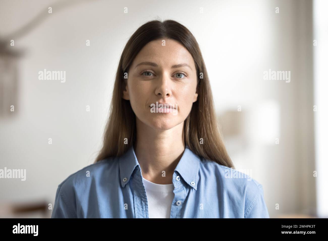 Positive young Caucasian woman with natural makeup looking at camera Stock Photo