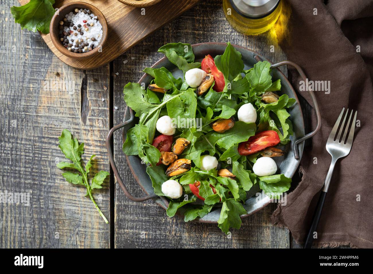 Healthy diet salad with arugula, mozzarella, mussels and vinaigrette