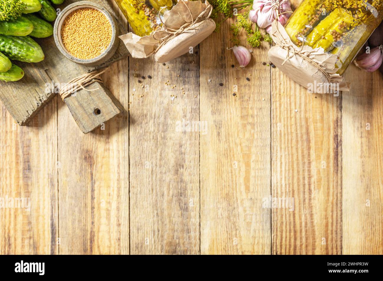 Healthy homemade fermented food. Salted pickled cucumbers with mustard preserved canned in glass jar. Home economics, autumn har Stock Photo