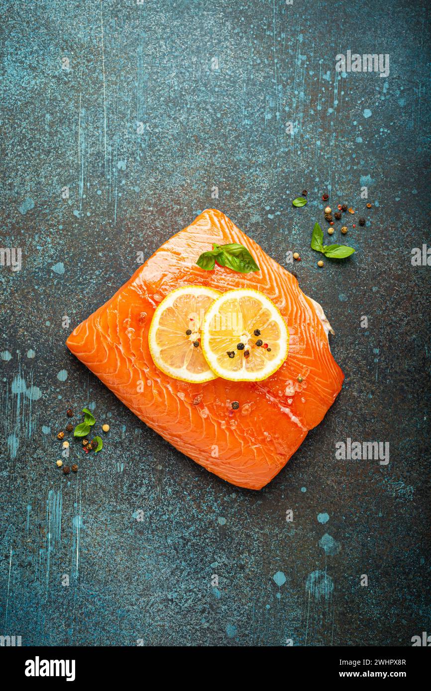 Fresh raw salmon marbled fillet on dark blue rustic concrete table ...