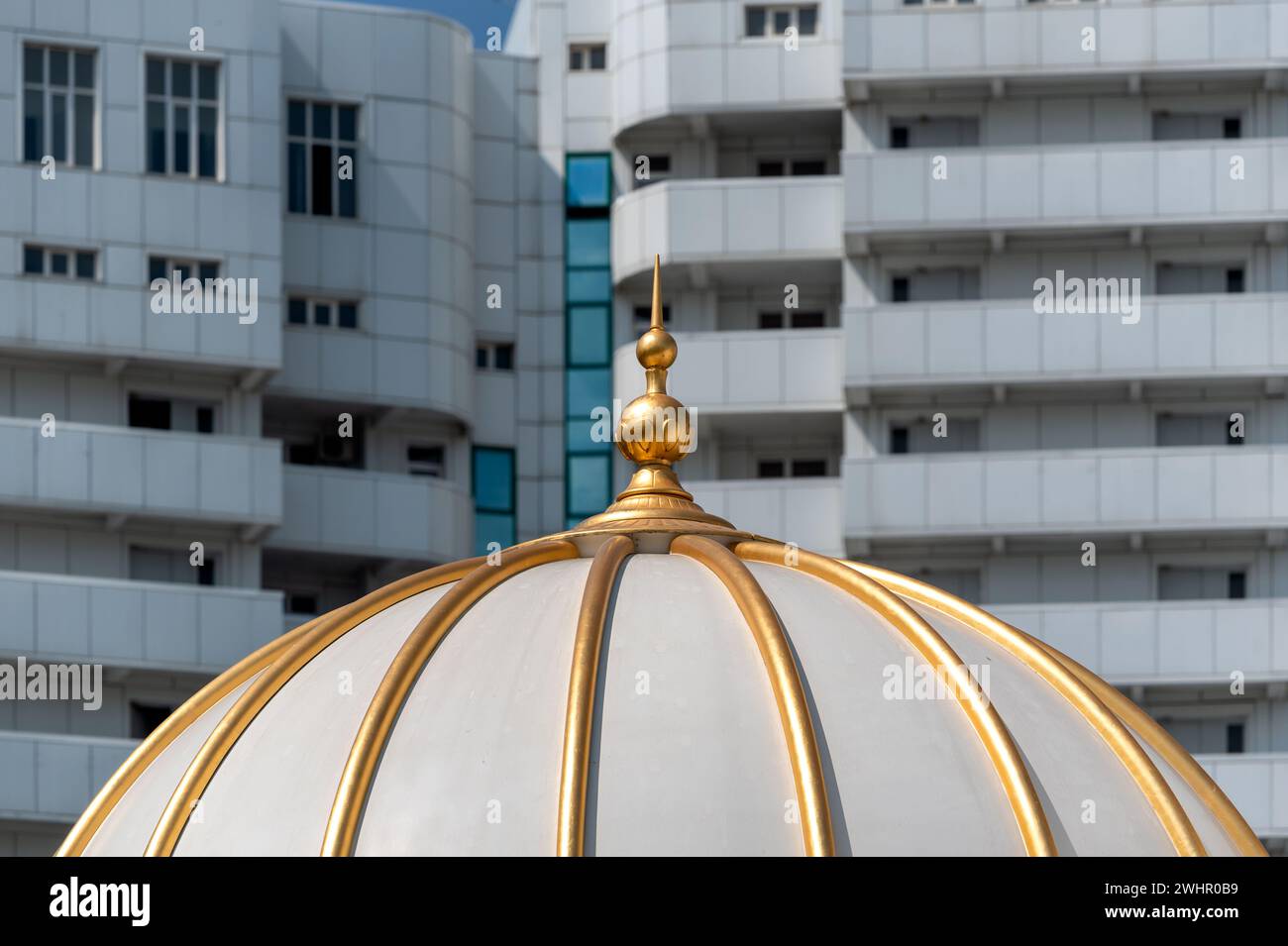 Dome of an Islamic mosque against the backdrop of modern houses Stock Photo