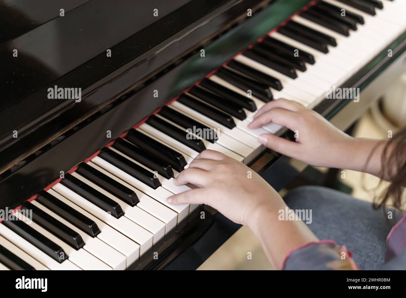 Girl learn to play piano.Â woman hand playing piano . Stock Photo