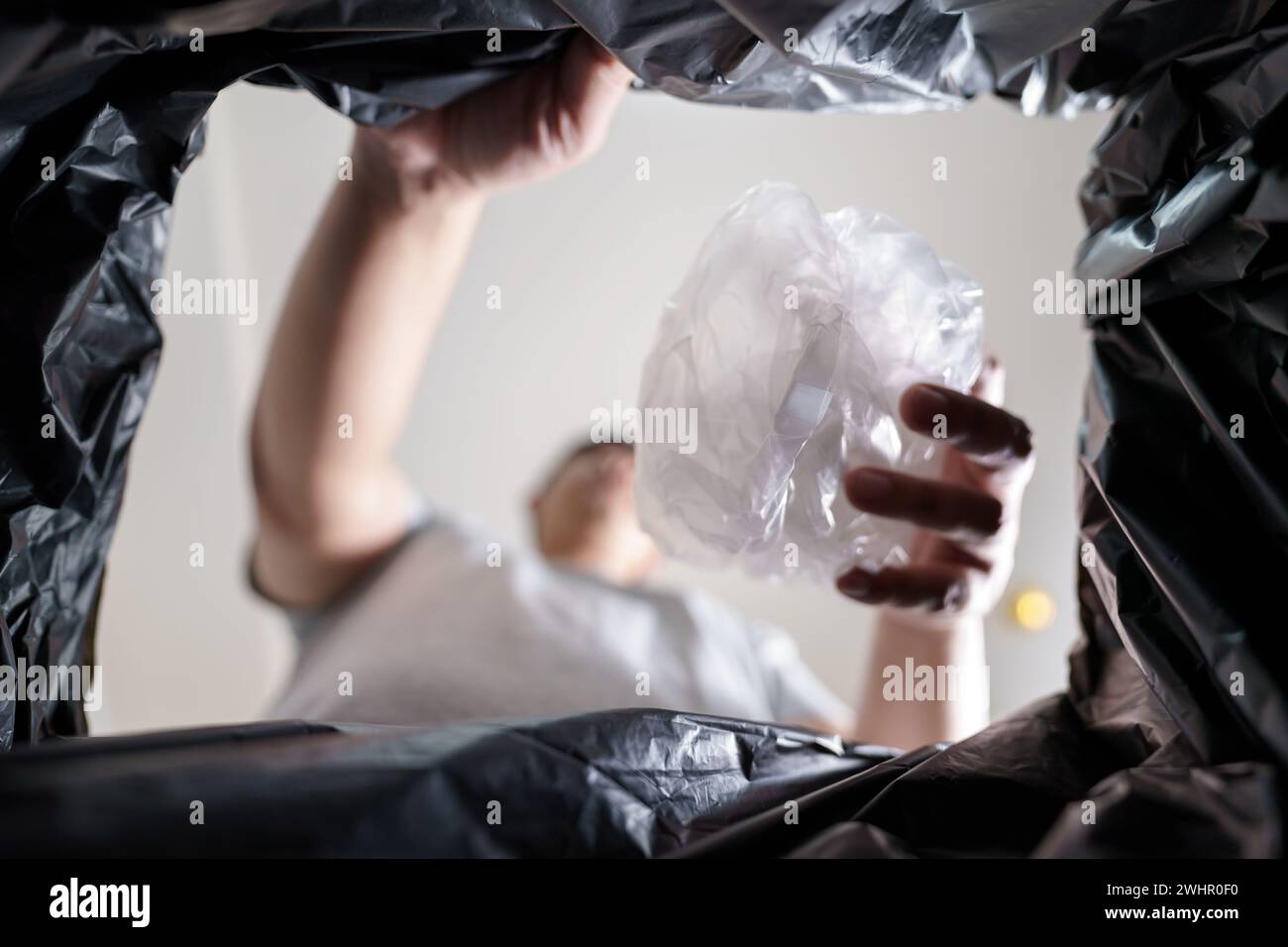 Image from inside yellow recycling bag of man throwing empty plastic bottle in recycling bin Home recycle eco green zero concept Stock Photo