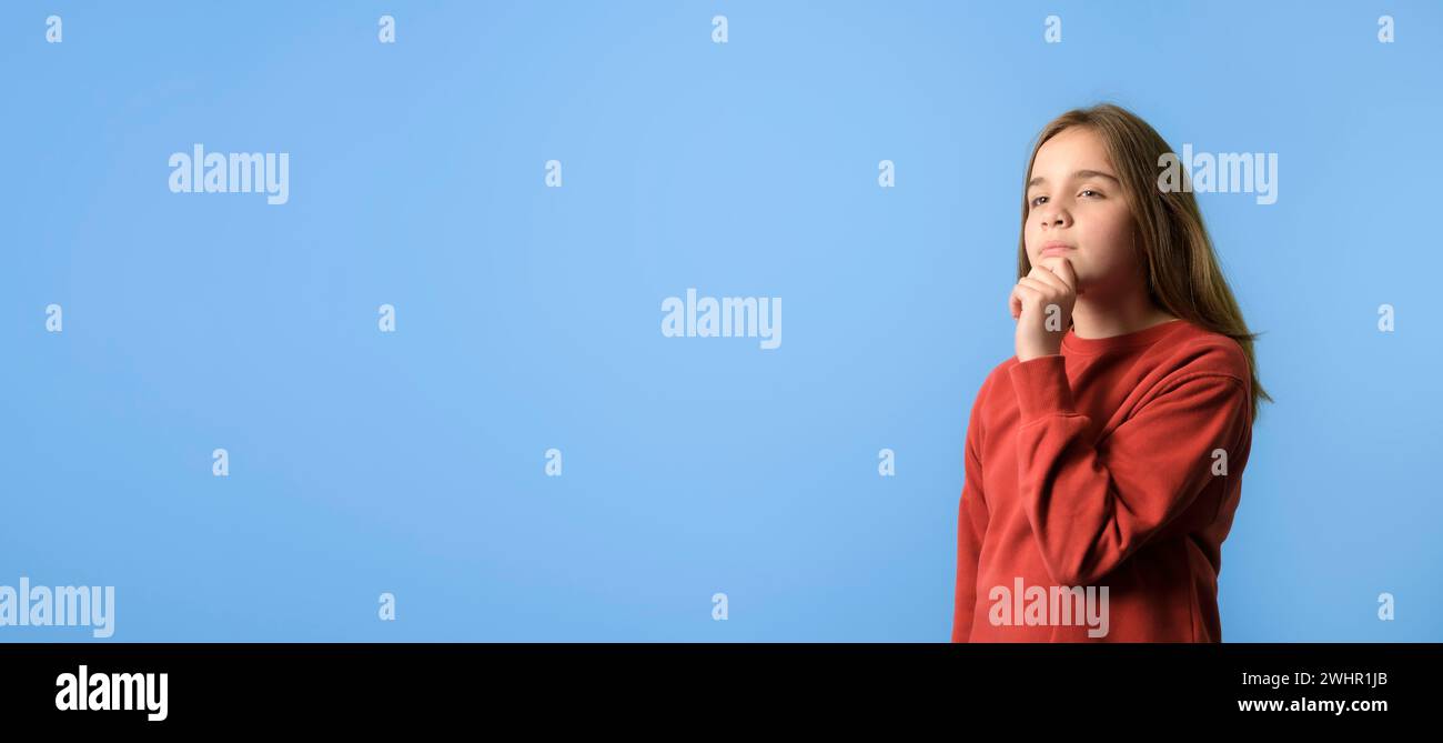 The new school year. Banner portrait of nice-looking teen girl 10 years old thinking creating new plan. copy space isolated blue background Stock Photo