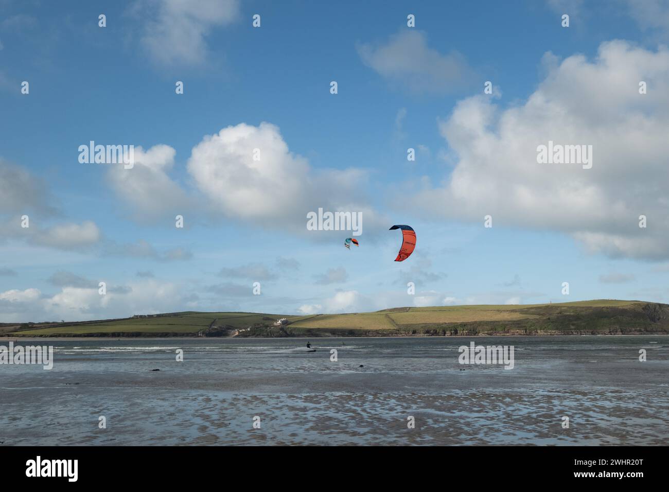 Daymer Bay, Cornwall, UK. 11th February 2024. UK Weather. Clear blue skies for the start of half term week in Cornwall. Seen here kite surfers making the most of the windy conditions. Credit Simon Maycock / Alamy live news. Stock Photo