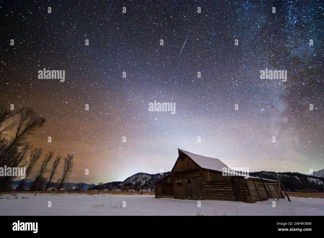 A Geminid meteor streaking through the night sky above the T.A. Moulton Barn. Grand Teton National Park, Wyoming Stock Photo