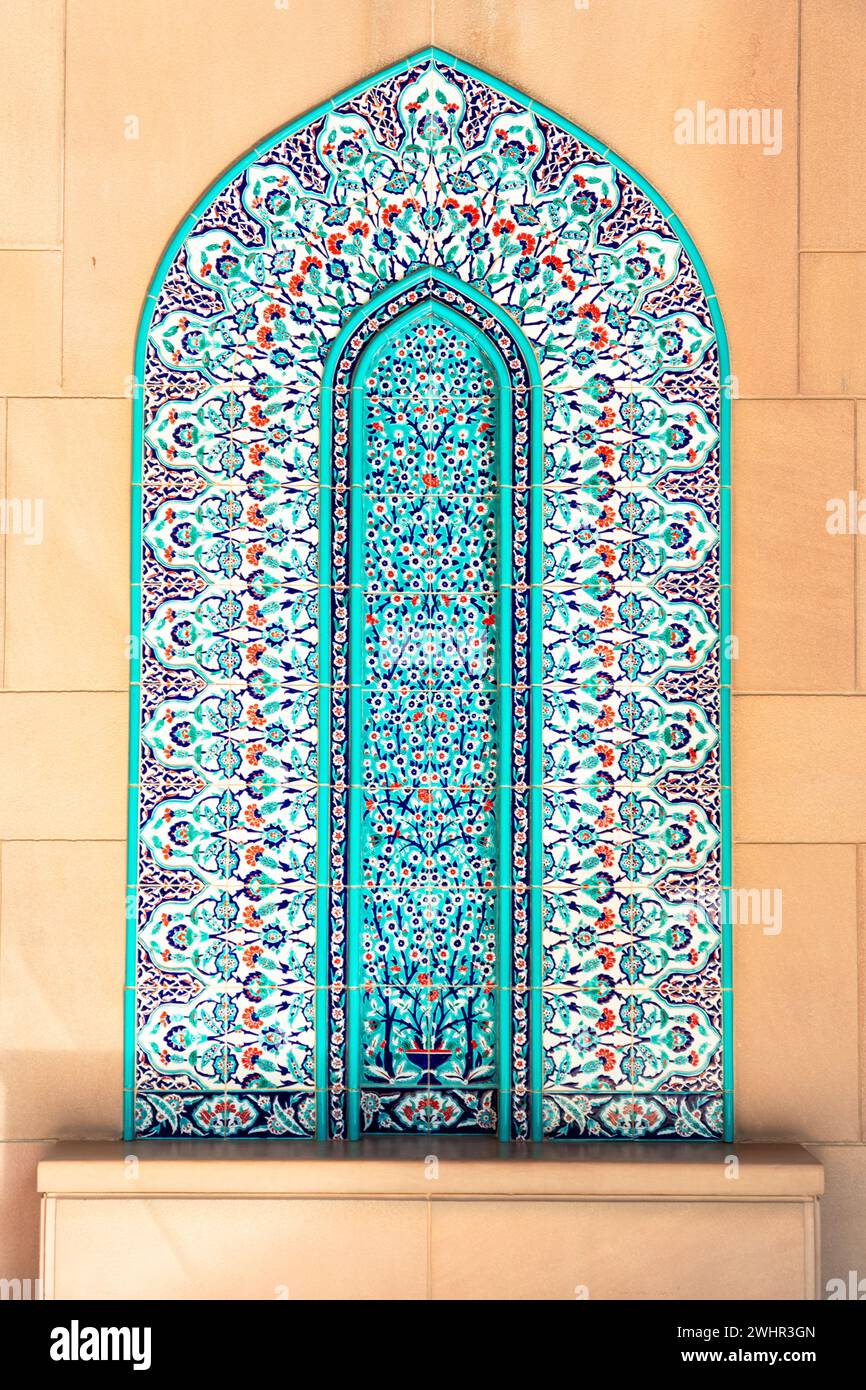 Vivid coloured turquoise traditional arch shaped mosaic on The Sultan Qaboos Grand Mosque interior wall Stock Photo