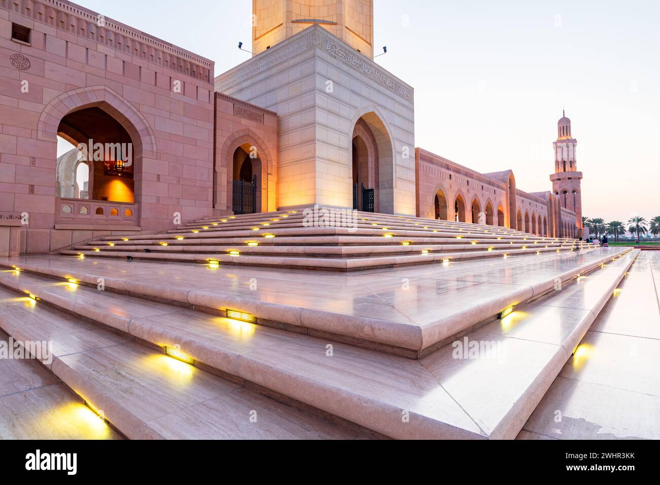 The Sultan Qaboos Grand Mosque low angle view with shiny steps in the foreground in the golden hour, Muscat, Oman Stock Photo