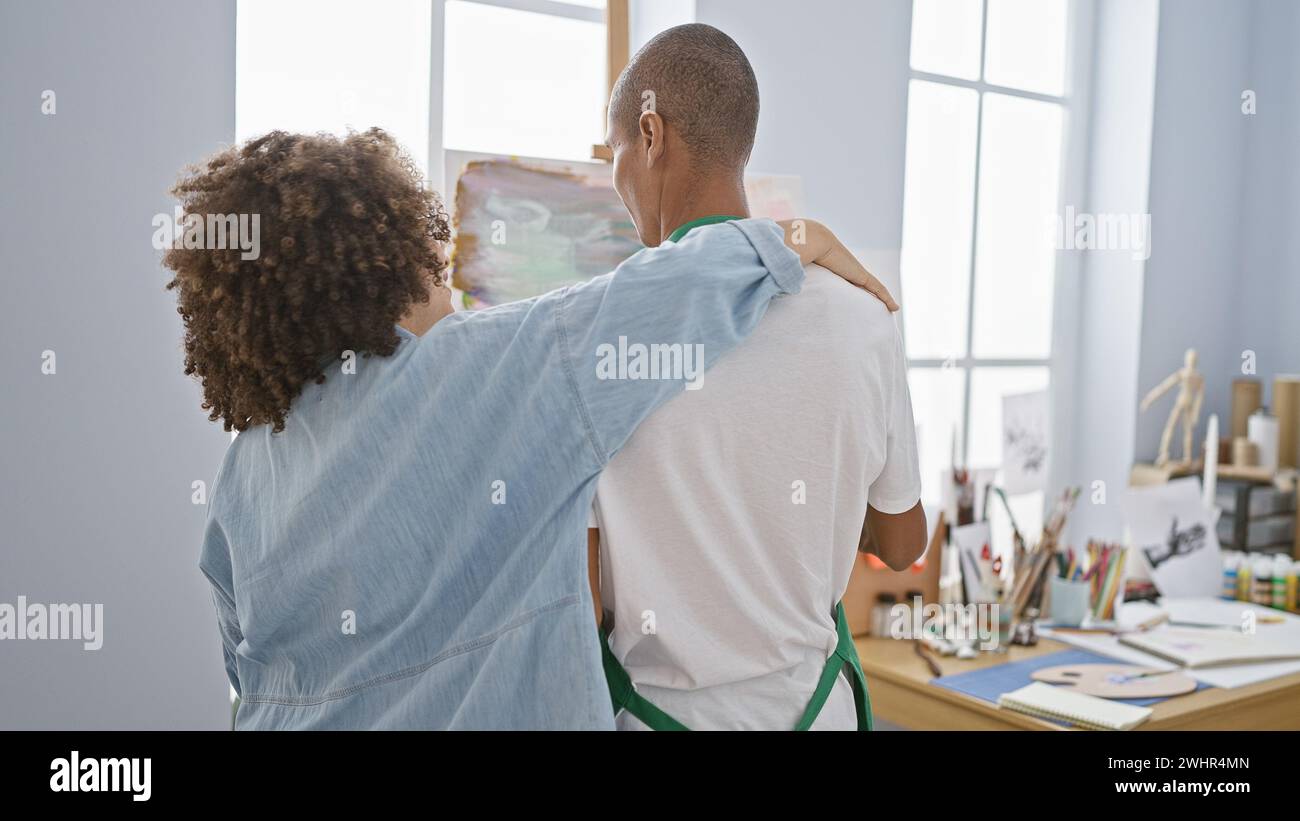 In an art studio, a man and woman artists exchange a heartwarming hug, drawing backwards together in a dance of creativity Stock Photo