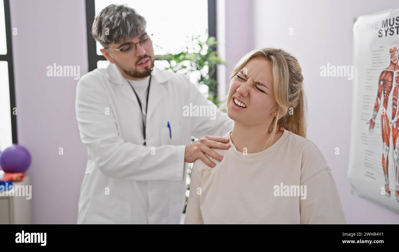 A male physiotherapist evaluates a woman's neck pain in a bright rehabilitation clinic. Stock Photo